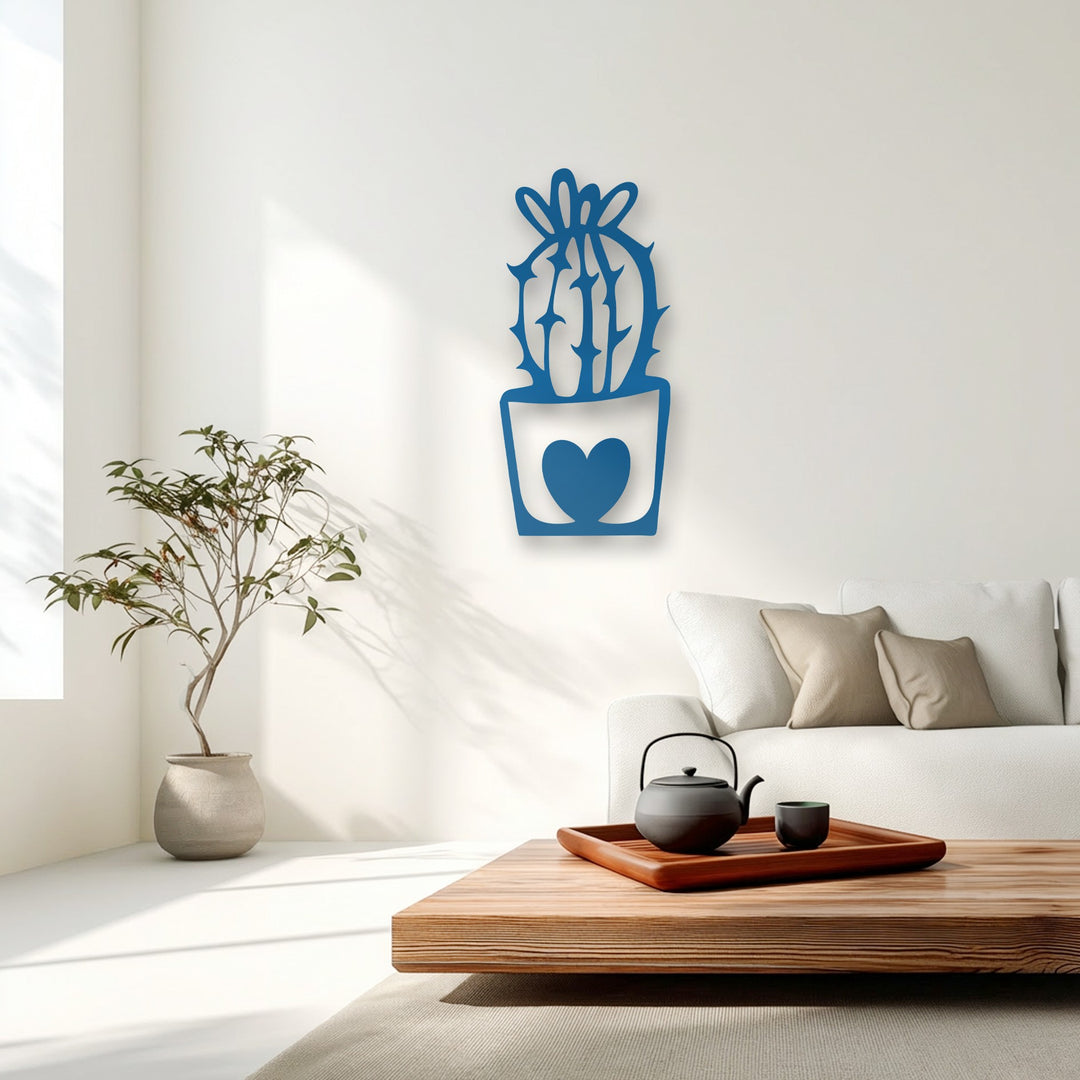 A dark teapot and cup ground the light room, contrasting the blue decorative metal art of a cute heart-potted cactus.