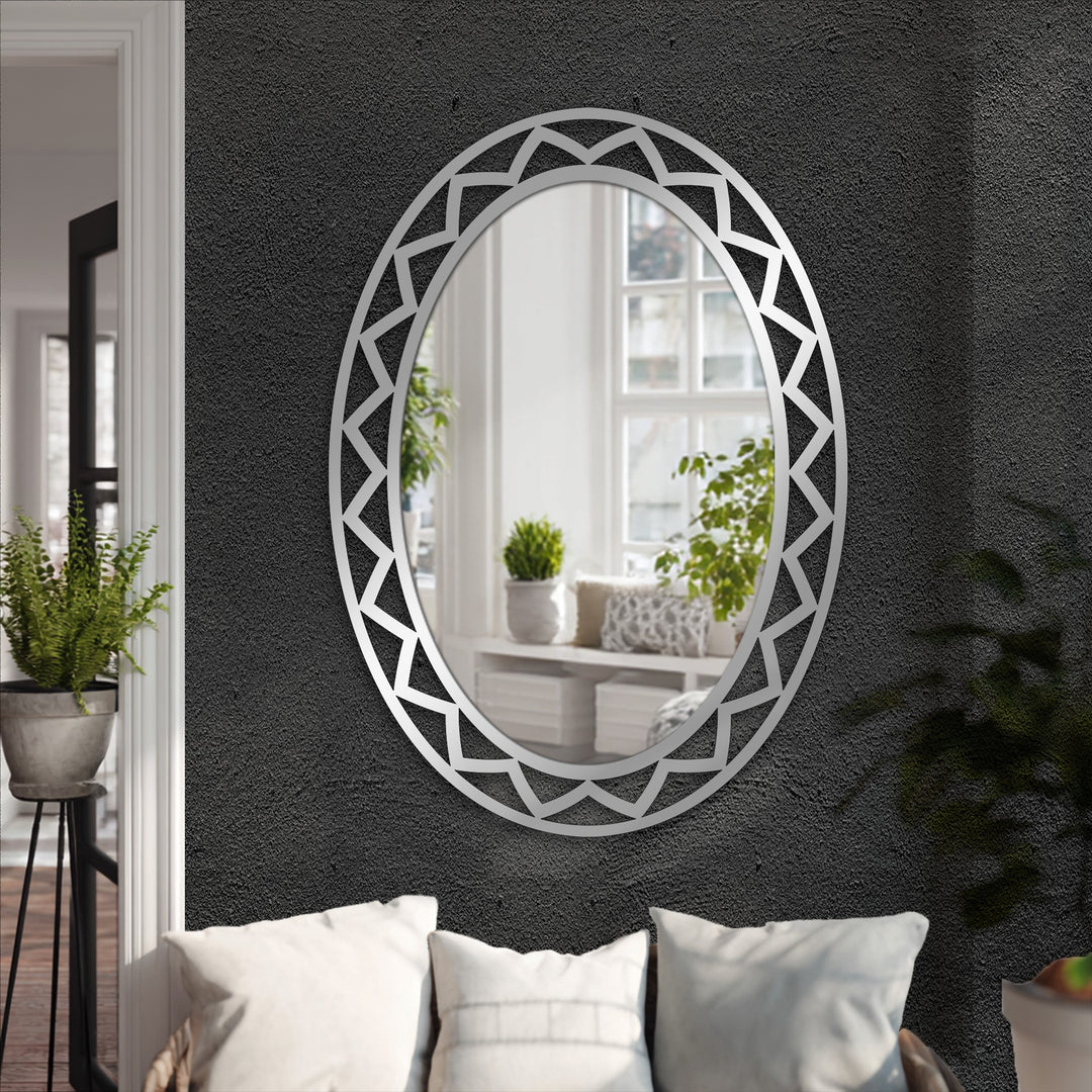 Black textured wall showcases a silver framed wall mirror with a geometric design, creating a reflective focal point with its decorative metal art.