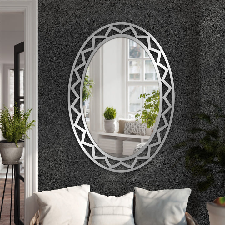 Black textured wall showcases a silver framed wall mirror with a geometric design, creating a reflective focal point with its decorative metal art.