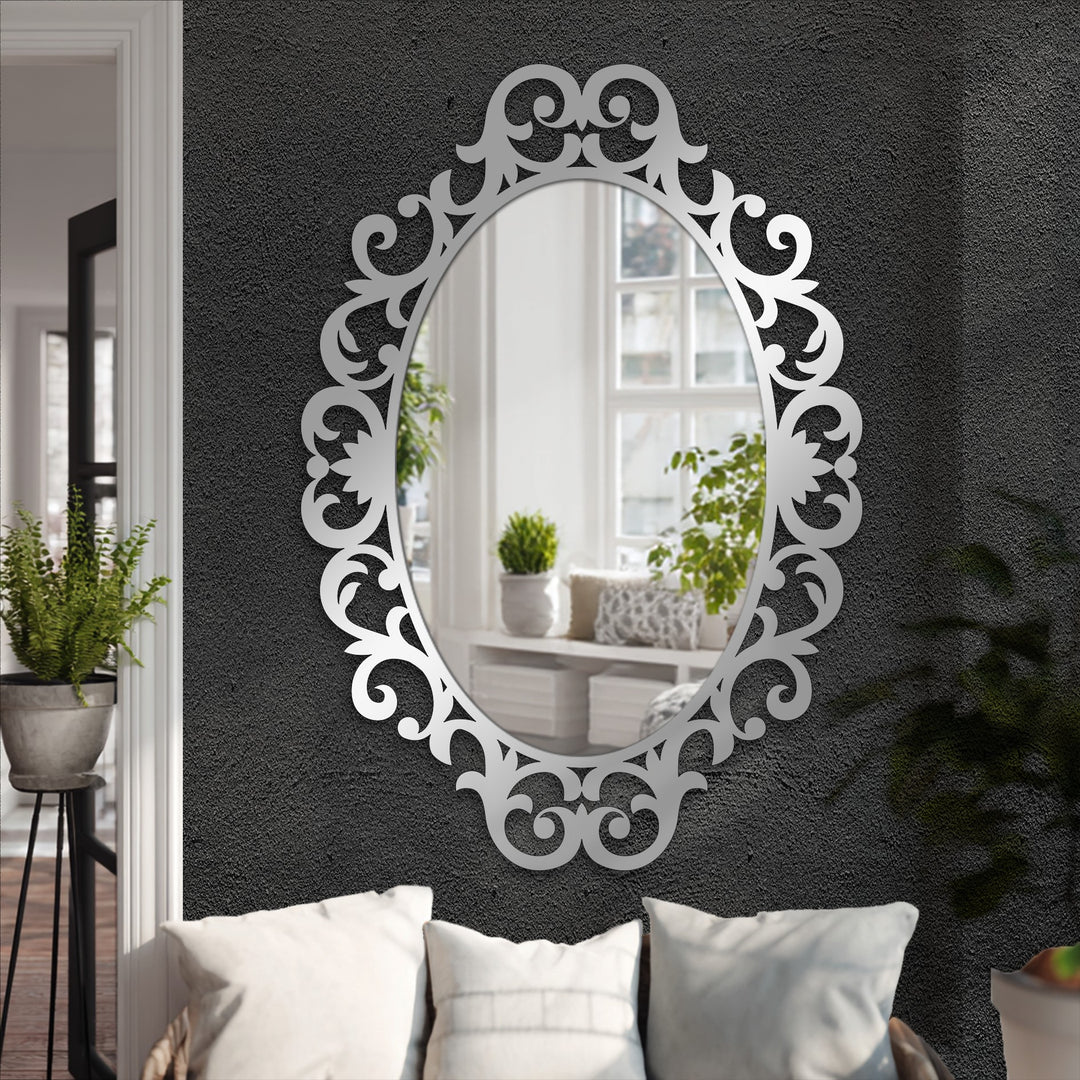 Low color saturation emphasizes the silver, ornate scrollwork frame surrounding the reflective surface of this modern mirror, adding a touch of elegance.
