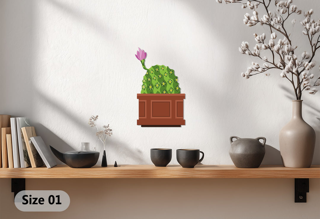 Crisp white background highlights the pink bloom cactus metal artwork displayed on a wooden shelf amidst decorative vases and books, showcasing unique metal artwork.