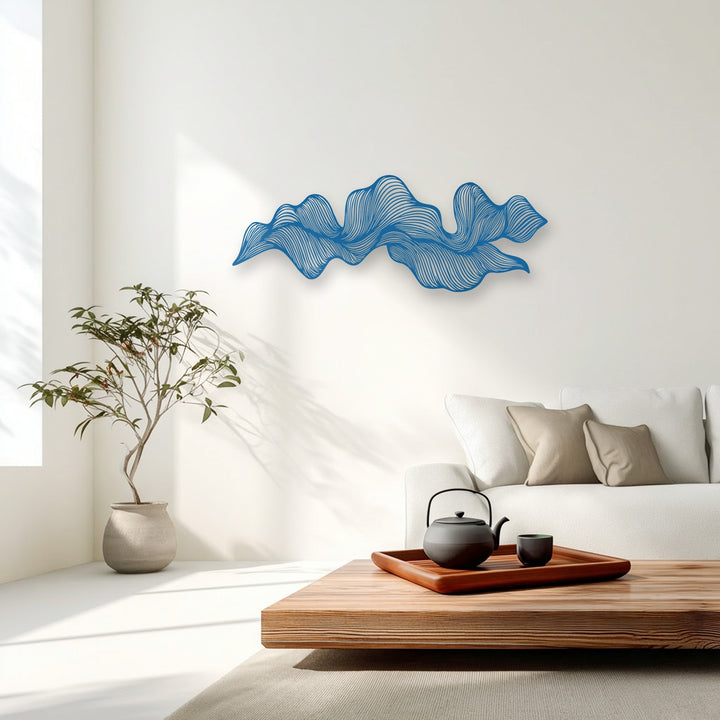 An elegant cerulean abstract wave flow metal artwork with delicate lines adorns a pristine white wall in a modern living room.
