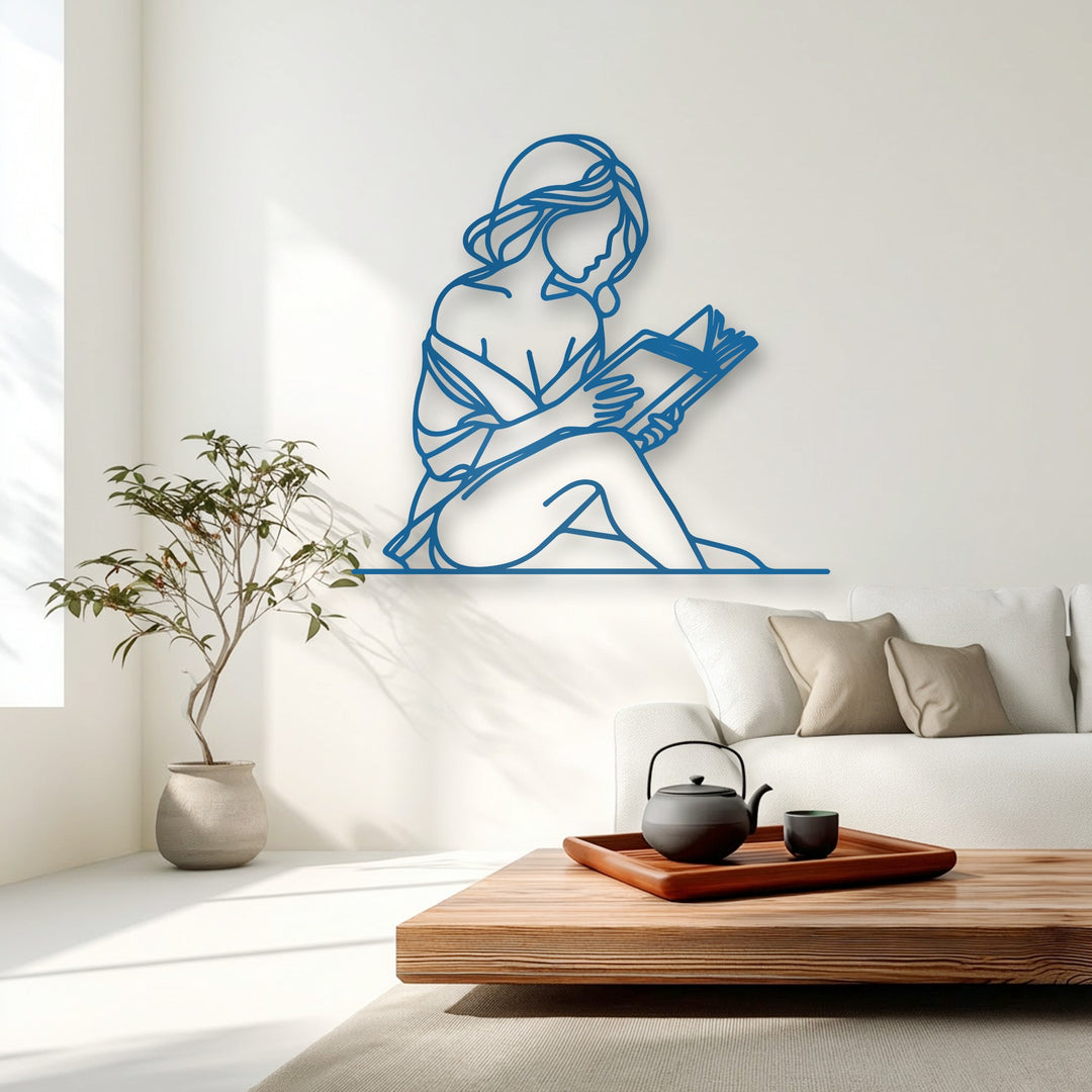 The vivid azure outline of the minimal woman reader metal art for wall sharply contrasts against the pristine white background, highlighting its elegant form.