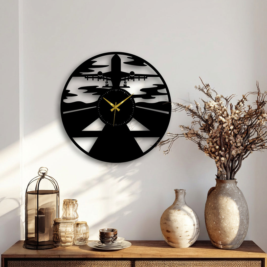 A sunlit wooden table in the foreground features a metal lantern and glass items, complementing the airplane silhouette metal artwork.