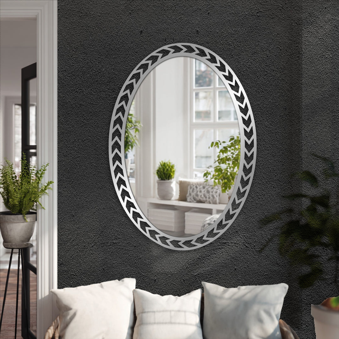 Black wall highlights the modern wall mirrors, featuring a geometric chevron edge oval mirror reflecting a bright interior scene.
