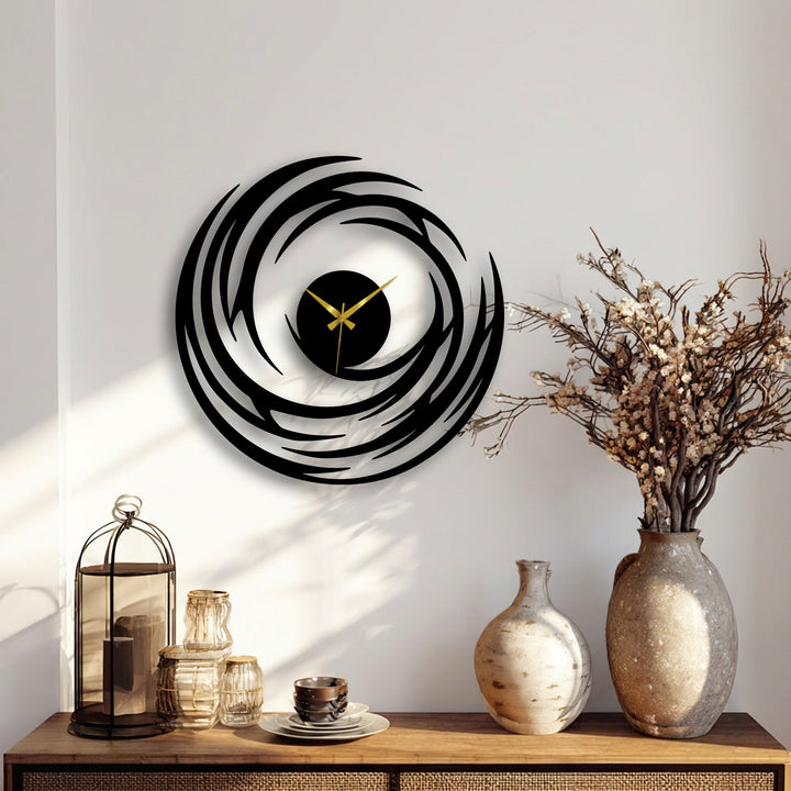Sharp color contrast highlights the black abstract spiral metal wall clock against the white wall, showcasing modern decoration wall art with its swirling design and bright gold clock hands.