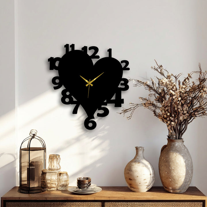 With layered elements, a unique metal wall art heart-shaped clock sits above a wooden console displaying decorative objects, creating visual depth.