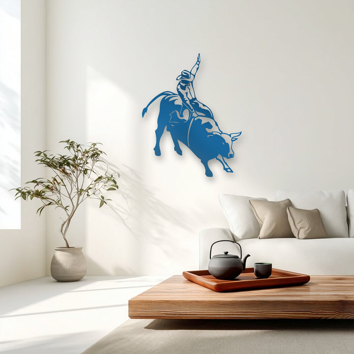Plush beige throw pillows soften the serene living space, complemented by a bold blue rodeo cowboy on bucking bull metal artwork.