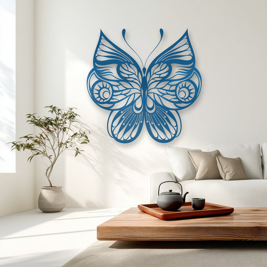 The layering effect of this deep blue ornate butterfly metal artwork casts beautiful shadows, enhancing its intricate decorative design on a bright wall.