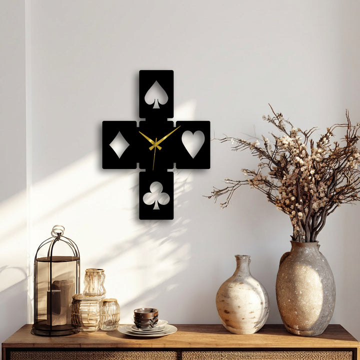 The brightest area on the pristine white wall prominently features the reflective playing card symbols of the unique metal wall art clock.