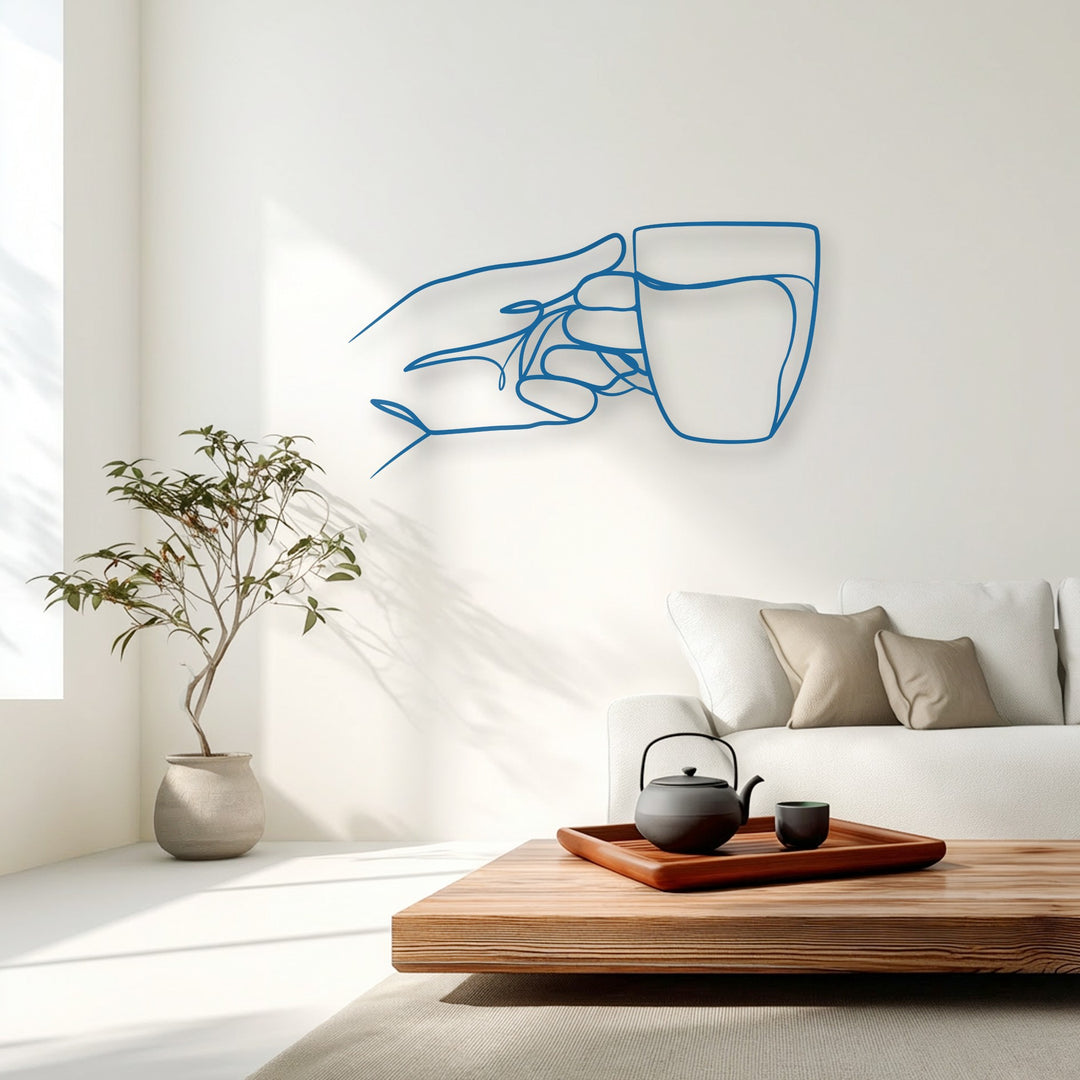 The vibrant azure blue minimalist hand holding cup line art is a unique metal wall art piece on a clean white wall.