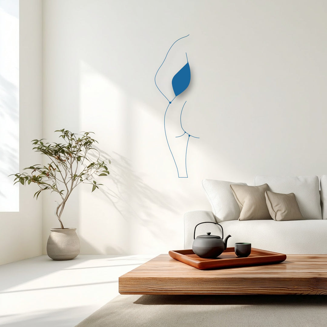 Graceful, fluid lines of a minimalist female silhouette metal decoration wall art evoke a dynamic sense of movement on a pristine white wall.
