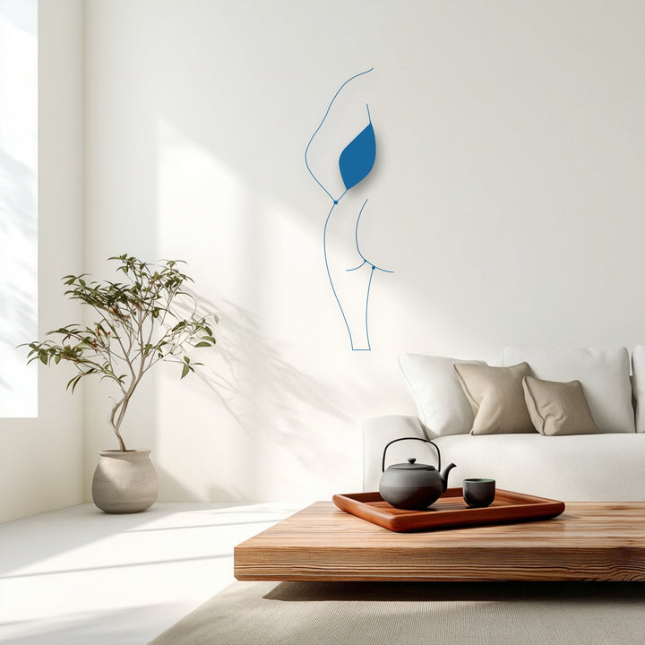 Graceful, fluid lines of a minimalist female silhouette metal decoration wall art evoke a dynamic sense of movement on a pristine white wall.