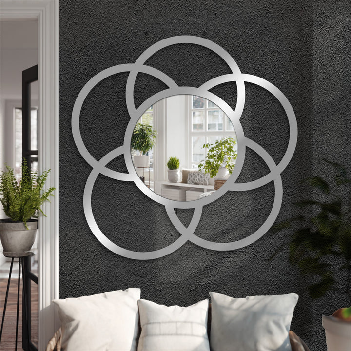 Brightest area highlights the reflected light in this modern mirror, framed with interlocking circles, blending seamlessly with a geometric metal art for wall design.