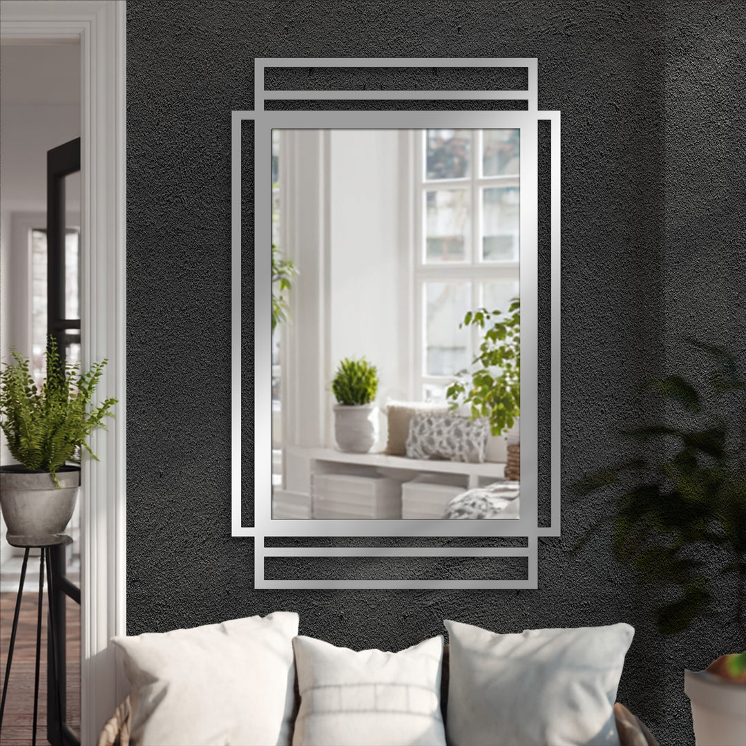 Cool color temperature illuminates the decorative mirror's geometric layered frame, contrasting with the minimal black lines and reflecting a brightly lit room.
