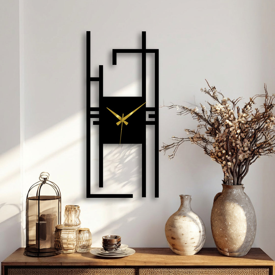 Foreground showcases the modern vertical abstract metal wall clock design with elegant decoration wall art alongside decorative vases on a wooden surface.