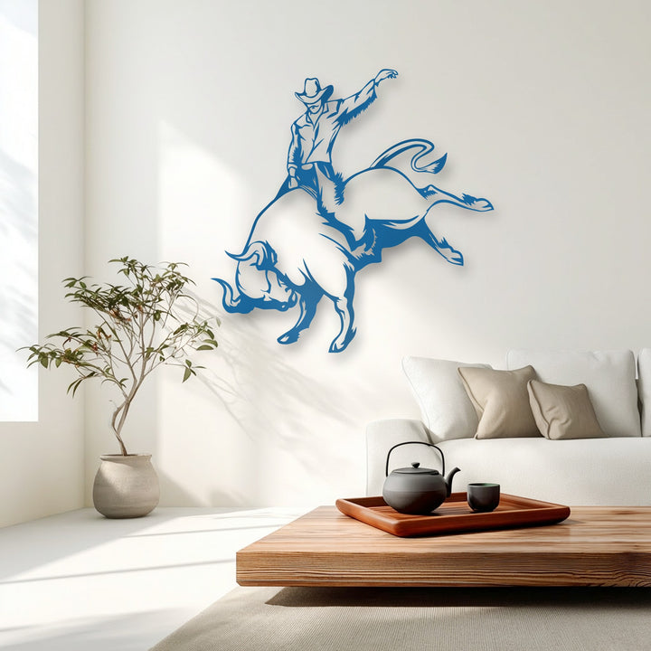 The matte blue finish of the dynamic cowboy bull riding metal art for wall creates a captivating silhouette on the light wall.