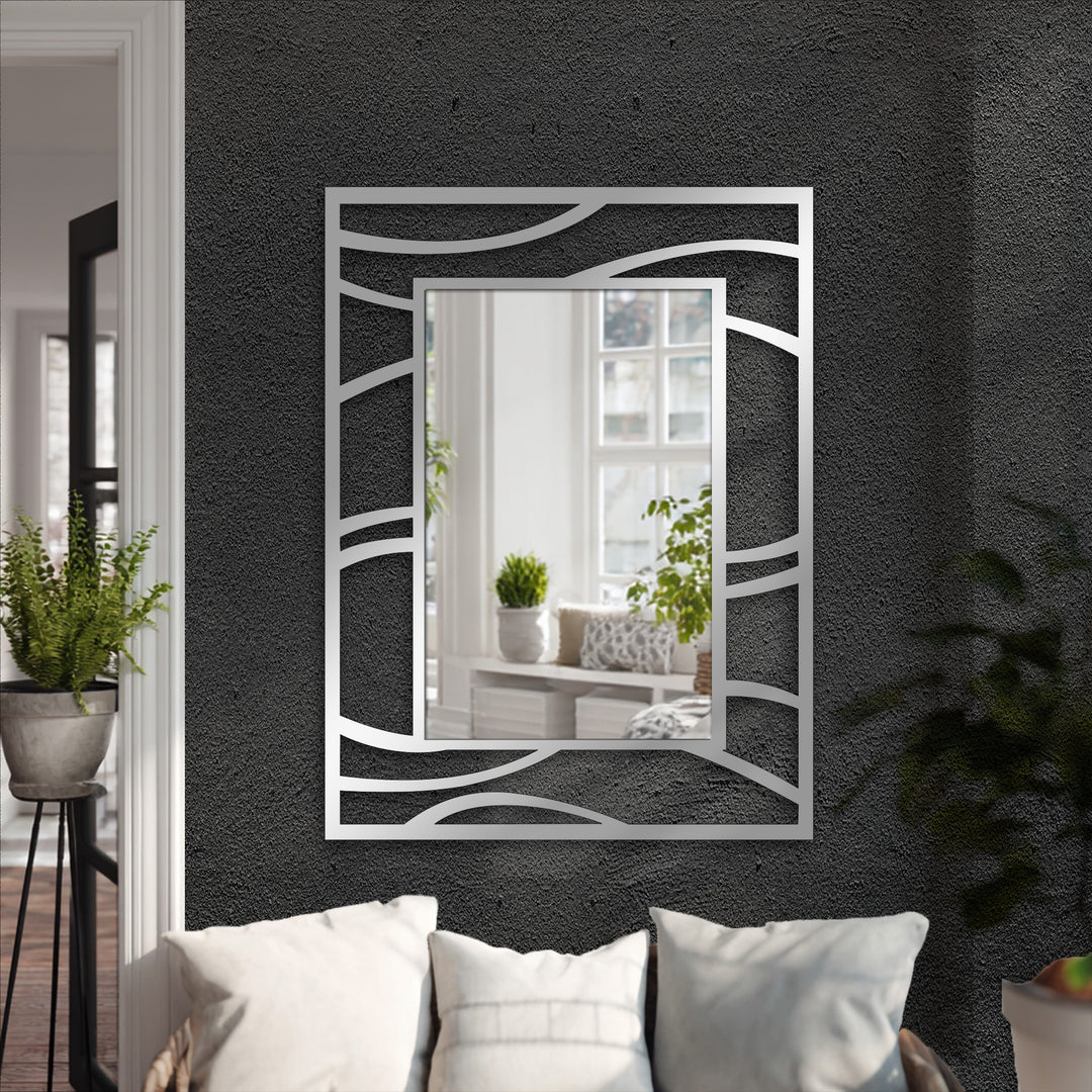 A bathroom mirror with an abstract wave frame highlights the fluid line design of the modern metal wall decor.