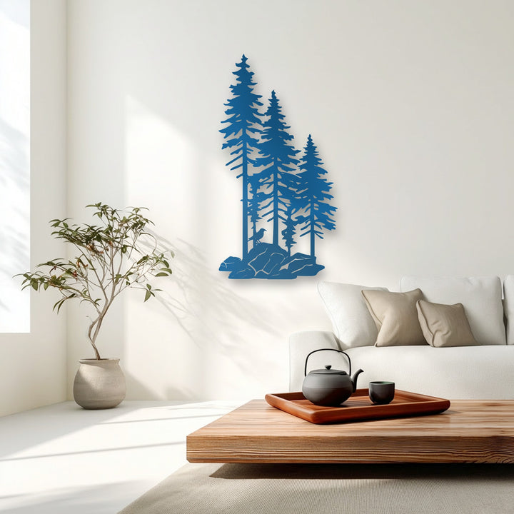 The bright white wall area beautifully highlights a striking blue forest pine trees metal art for wall, with subtle shadows.