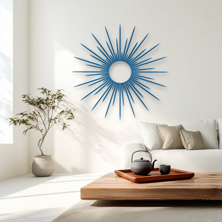 The layered design of this vibrant azure sunburst metal artwork highlights its modern abstract circle with pointed, radiating rays.
