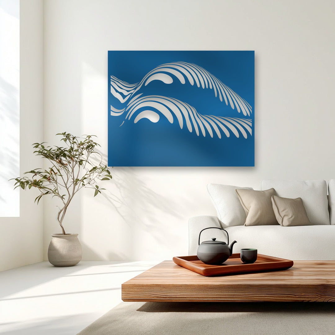 The vibrant sapphire blue background of the abstract ocean wave metal artwork provides a stark color contrast to the lustrous white, undulating forms.