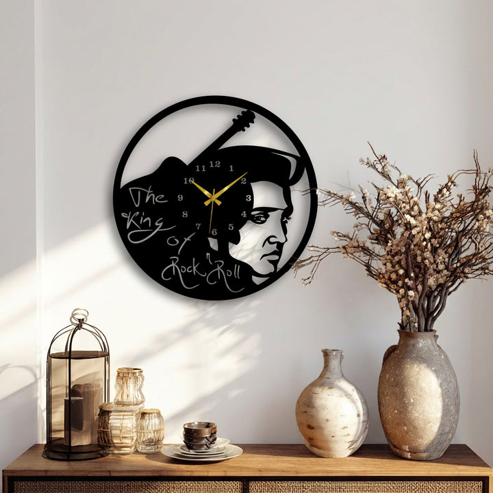 Subtle light and dramatic shadows highlight the intricate Elvis Presley rock music icon decorative metal art wall clock with guitar design.