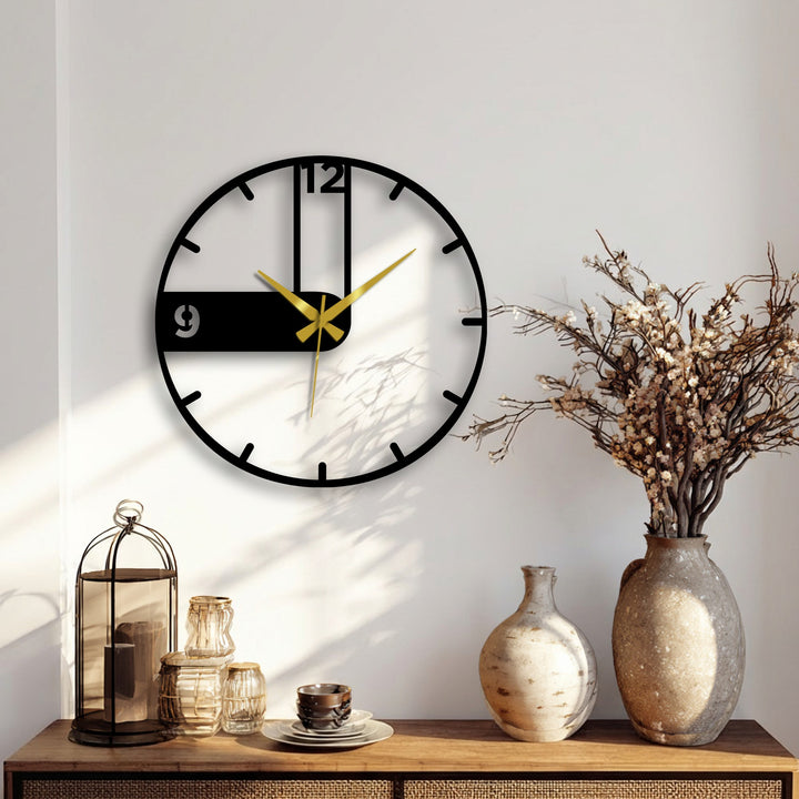 Illuminated by a bright ray, the minimalist modern asymmetrical black metal wall clock adds a striking touch of decorative metal art to the room's home decor.