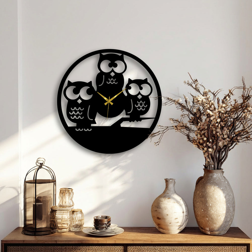 The pristine white wall, subtly highlighted by natural sunlight and soft shadows, enhances the modern Three Owls Silhouette metal wall decor.