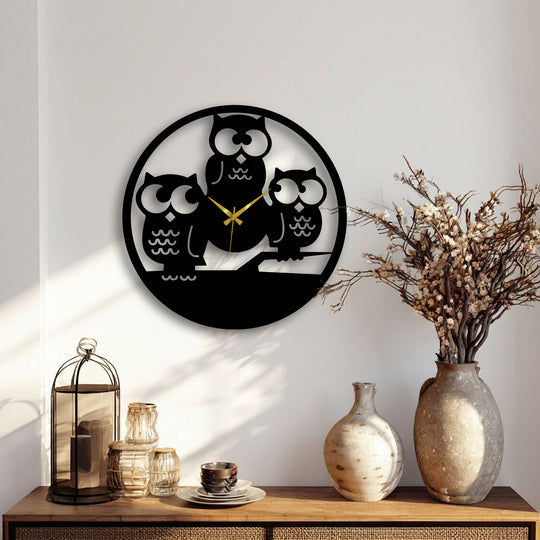 The pristine white wall, subtly highlighted by natural sunlight and soft shadows, enhances the modern Three Owls Silhouette metal wall decor.