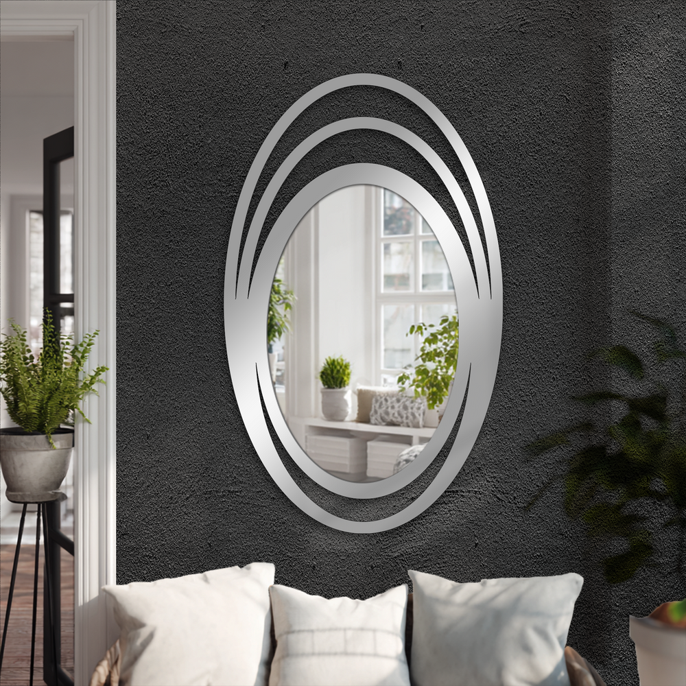 Soft pillows create a welcoming base below the triple halo oval decorative mirror, reflecting a bright interior scene.