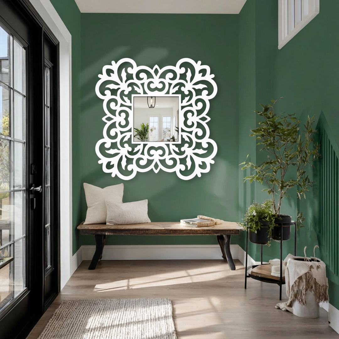 Foreground detail showcases a stylish modern mirror with an ornate floral scroll frame, a decorative metal wall decor that adds elegance to the entryway.