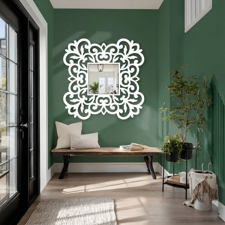 Foreground detail showcases a stylish modern mirror with an ornate floral scroll frame, a decorative metal wall decor that adds elegance to the entryway.