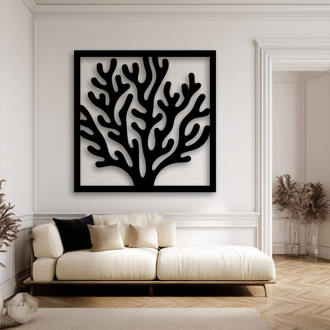 Soft light and deep shadows define the delicate, intertwining branches of the unique metal wall art coral frame, creating depth against the bright wall.