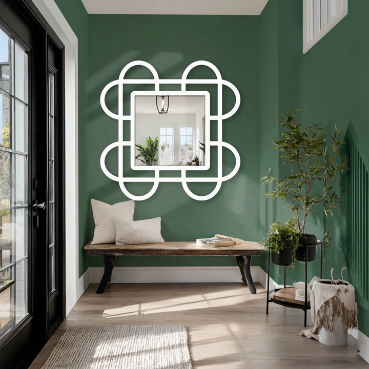 The decorative mirror has a unique edge defined by a white, looped square frame, adding a modern geometric touch that enhances its reflection.