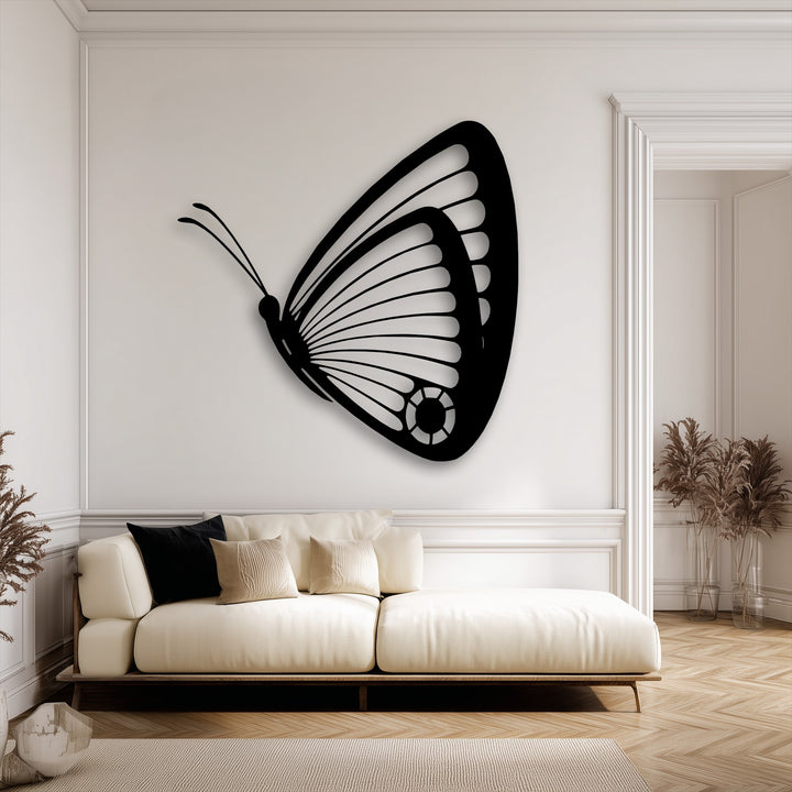 The sleek, matte black finish of the graceful butterfly metal wall decor creates an elegant silhouette against the light wall.