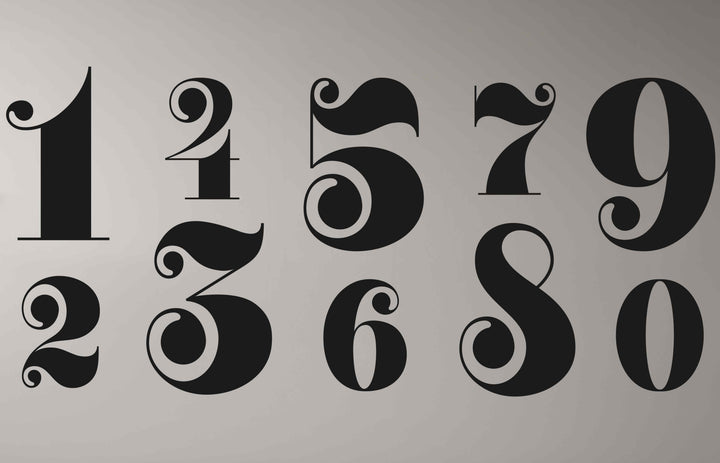 Stillness pervades this display of vintage style metal house numbers, a collection offering unique metal wall art, ideal for adding a touch of decor.