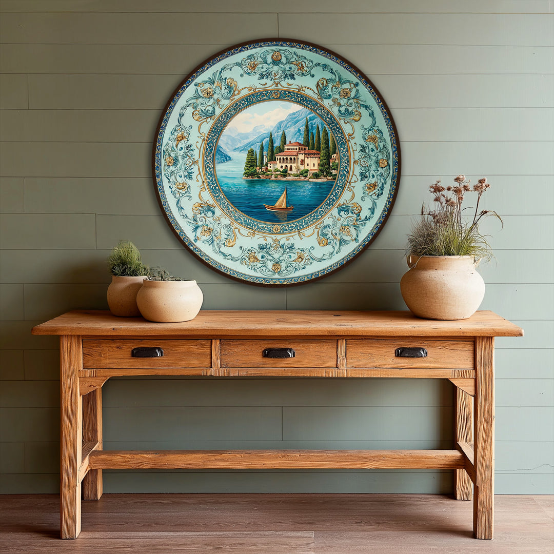 Dominated by tranquil turquoise, the modern oil painting art showcases a round landscape scene of a Mediterranean villa and lake with an ornate border.