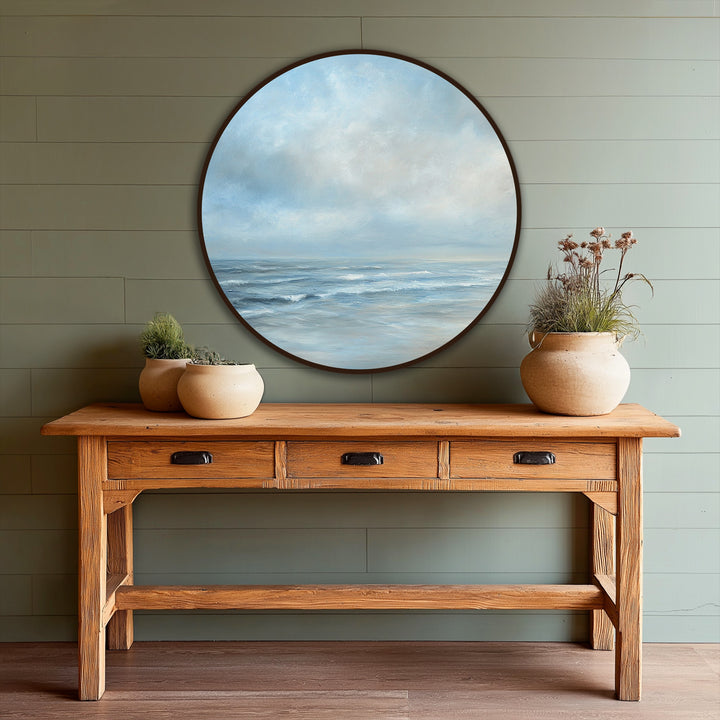 Swirling ocean waves in this round seascape oil painting artwork create a sense of dynamic movement, pulling the viewer into its serene coastal scene.