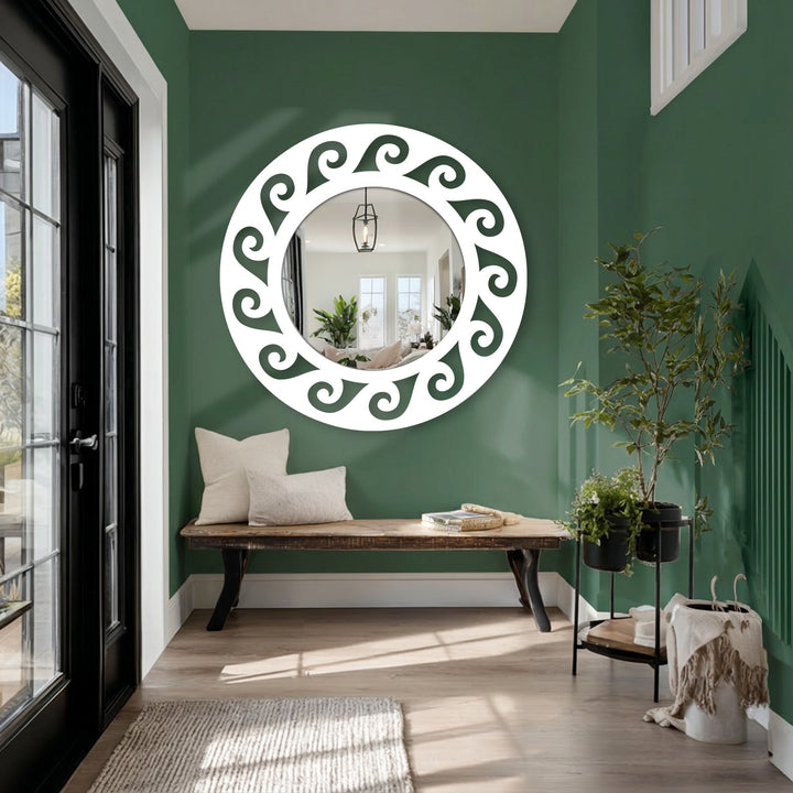Round stained glass wall mirror shows a stylish, horizontally-oriented design with a white decorative frame and scroll details, reflecting a bright interior.