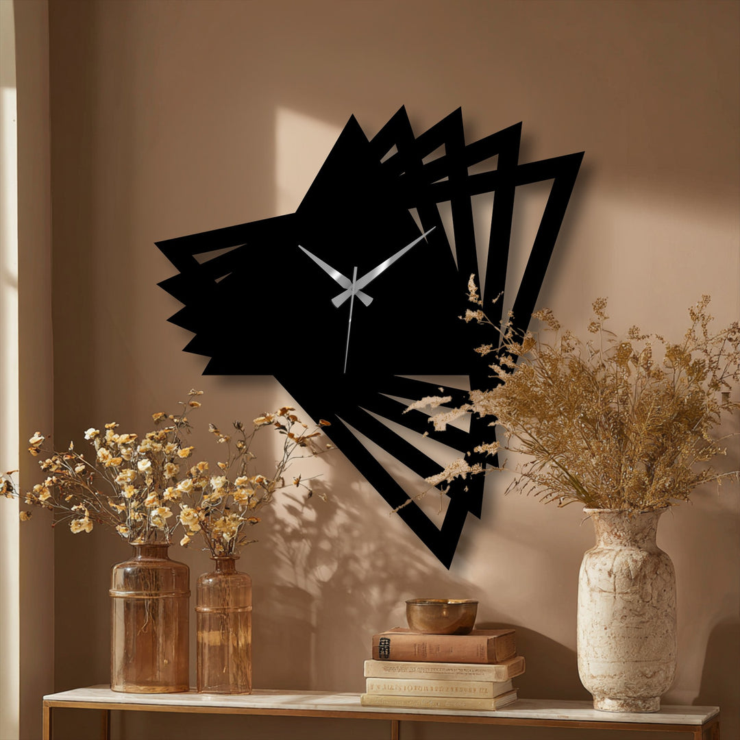 The spiraling, geometric triangles of the abstract origami modern metal artwork wall clock seem to swirl from the wall, creating dynamic movement.