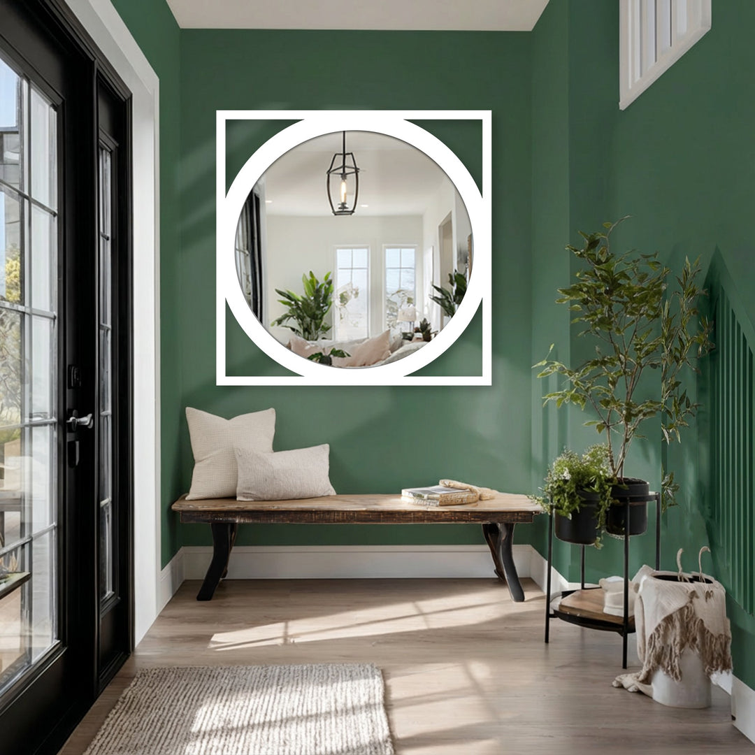 Green walls accentuate the geometric black metal frame of the round floor mirror, enhancing the room's aesthetics with unique metal wall art.