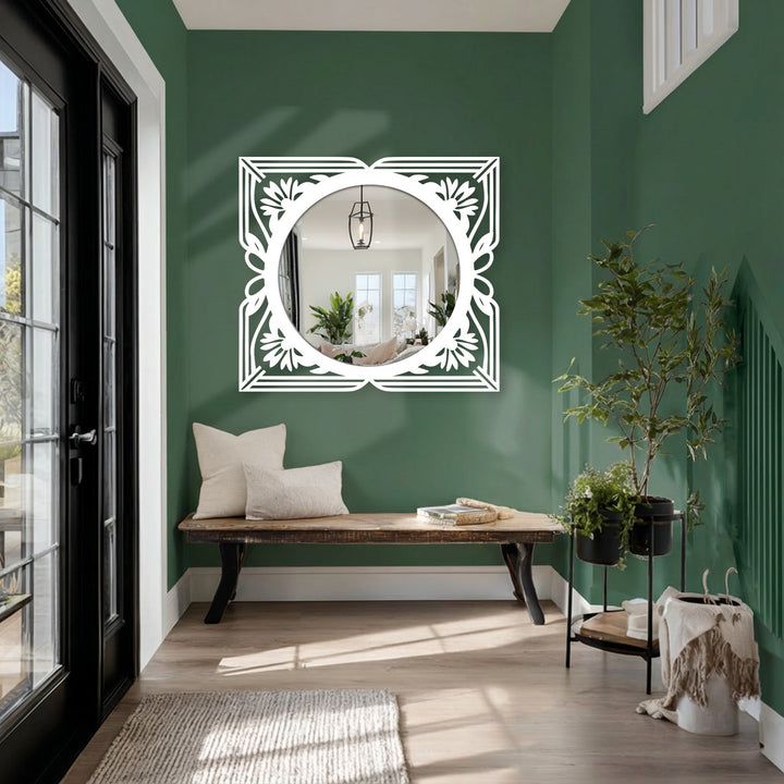 Ornate bathroom mirror with a smooth, round glass surface contrasting with the textured floral detailing of the art deco black metal artwork frame.