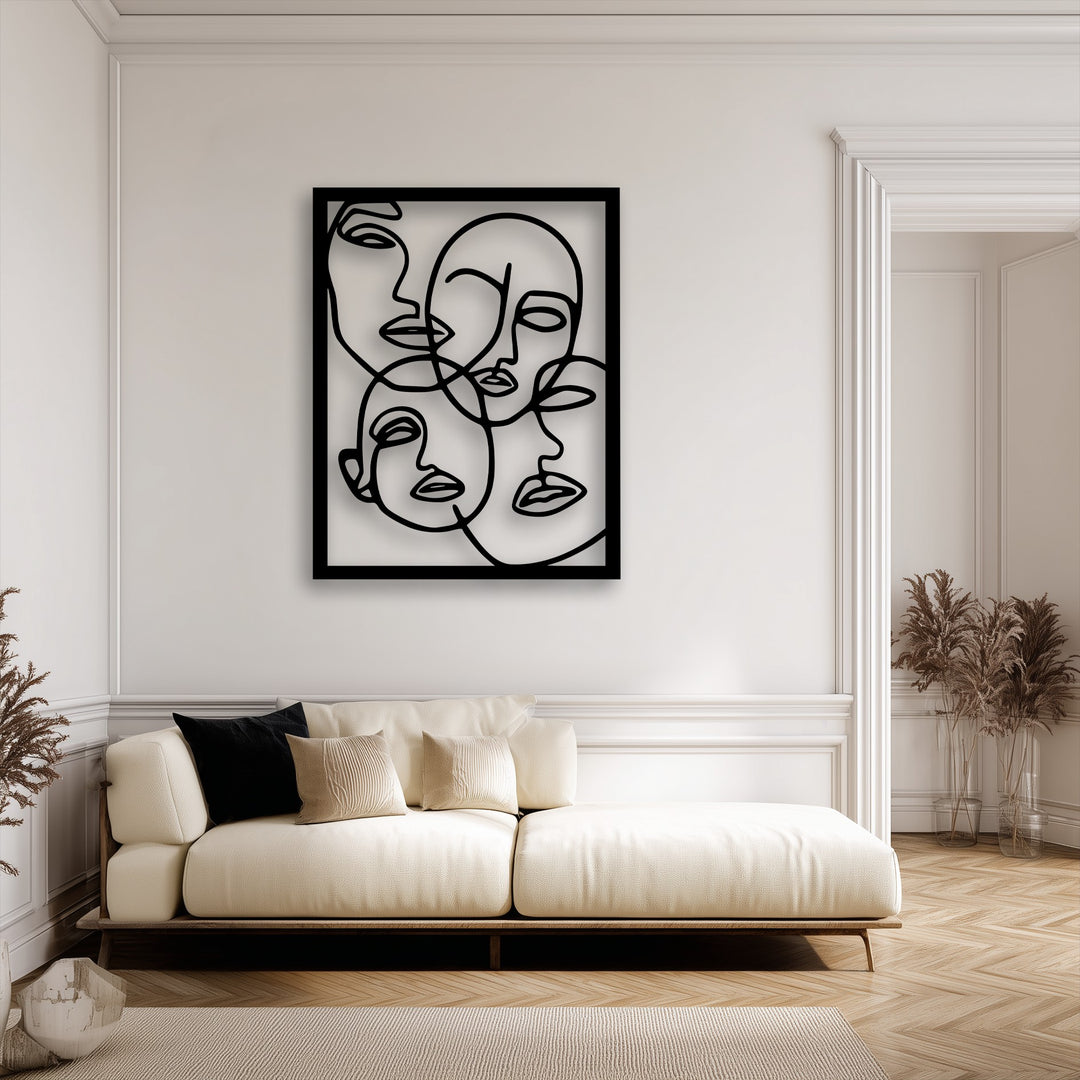 A cream textured rug and the wooden base of a modern sofa frame a minimalist metal artwork featuring abstract faces in line art.