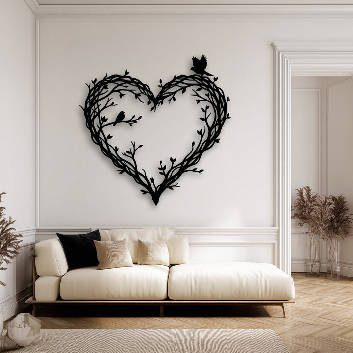 The matte black finish of this decorative metal art creates a striking silhouette of a heart formed by branches and birds.