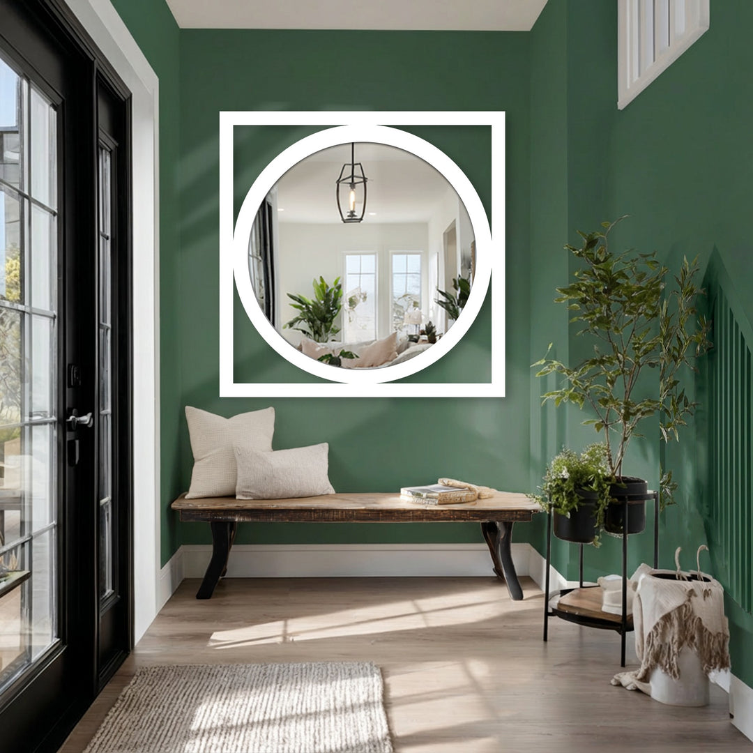 Contrasting hues highlight the square framed round mirror for wall decor, offering a stark visual against the deep green backdrop in a modern entryway.