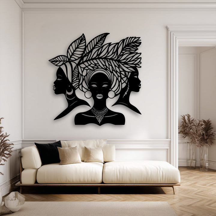 The stark contrast between the black decorative metal art of African queens and the soft cream wall provides a striking visual transition.