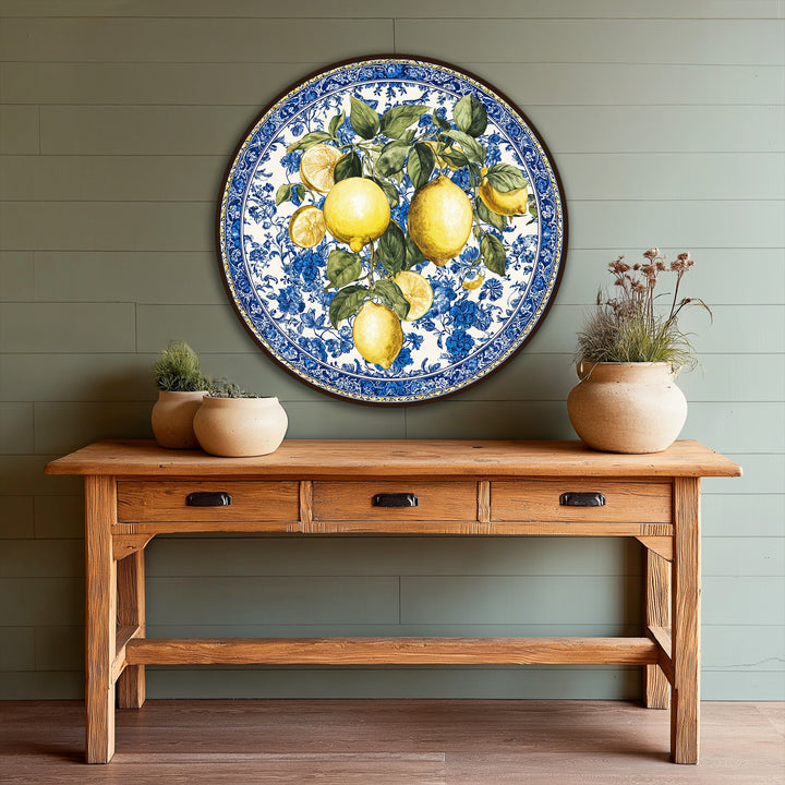 Warm, rustic wooden console table with three drawers positioned in the foreground supporting potted greenery below a lemon-themed oil painting artwork.