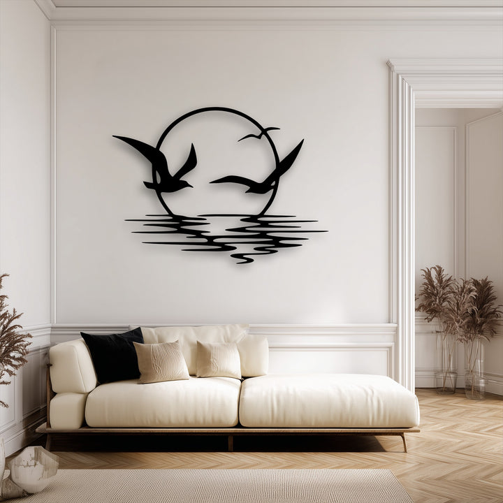 The striking black silhouette of soaring seagulls over a serene circular sunset reflection forms the focal point of the elegant metal art for wall.