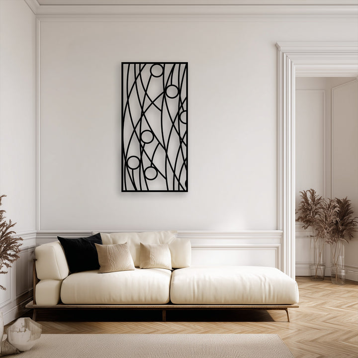The striking abstract linear geometry metal artwork panel, with bold black lines and circles, dominates the clean white wall.