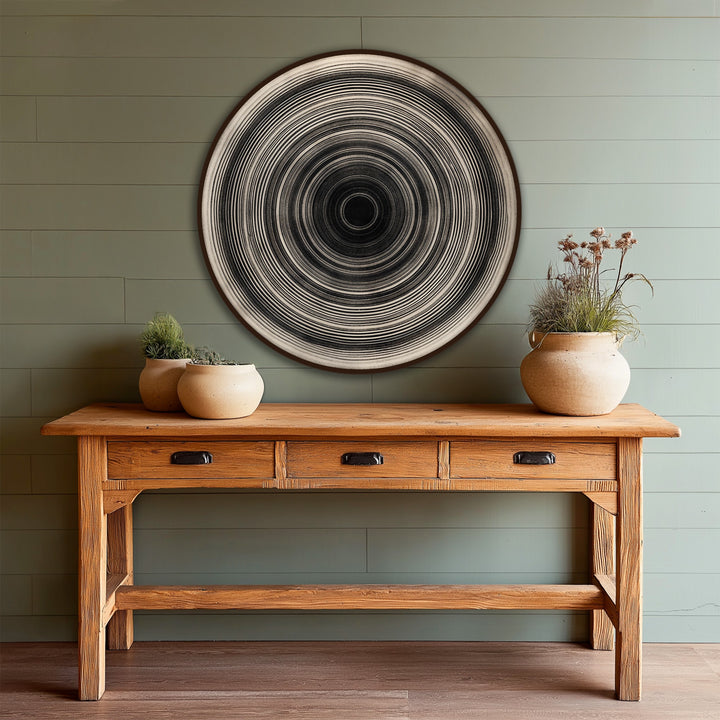 With a cool color temperature, this modern oil painting art piece, 'Monochrome Pulse,' showcases a minimalist circular design featuring concentric monochrome lines on wood.